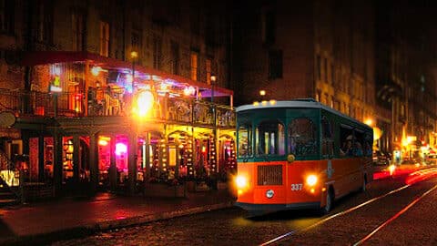 Where to See Holiday Lights in Savannah orange and green trolley