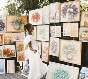Support the Local Creative Community at Savannah's Local Artist Market. a woman looking at art
