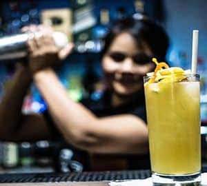 Where to Go for Cocktail Classes in Savannah. a bartender shaking a drink behind a bar