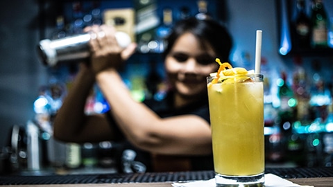 Where to Go for Cocktail Classes in Savannah. a bartender shaking a drink behind a bar