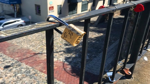 Love Lock Bridge. a padlock on a bridge with writing