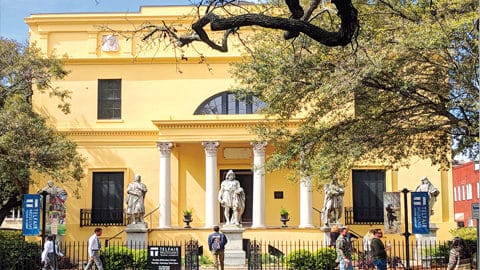 Savannah Brings History. Yellow building with columns and three statues