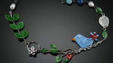 Signature Gallery. A necklace with a blue bird and leaves