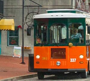 How to See Savannah. Old Town Trolley. Orange trolley stops on street